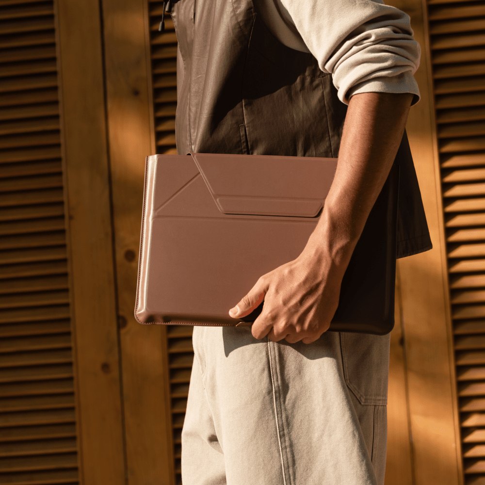 Мужчина несёт чехол MOFT Carry Sleeve с ноутбуком в руке